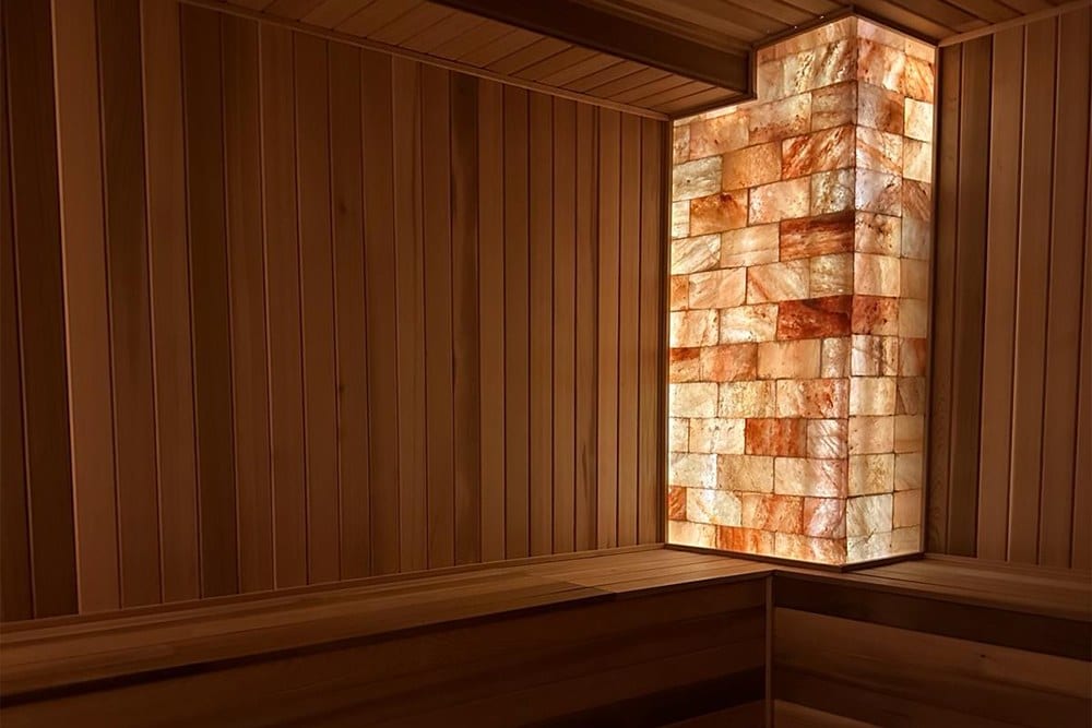 Himalayan salt cave interior with a glowing salt brick wall at Salt Secret in Waterloo